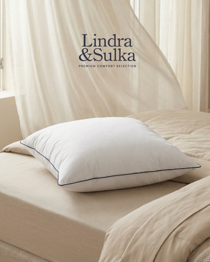 magnifique oreiller Aurore, posé sur un lit, une brise d'air frais soulève le rideau derrière le lit